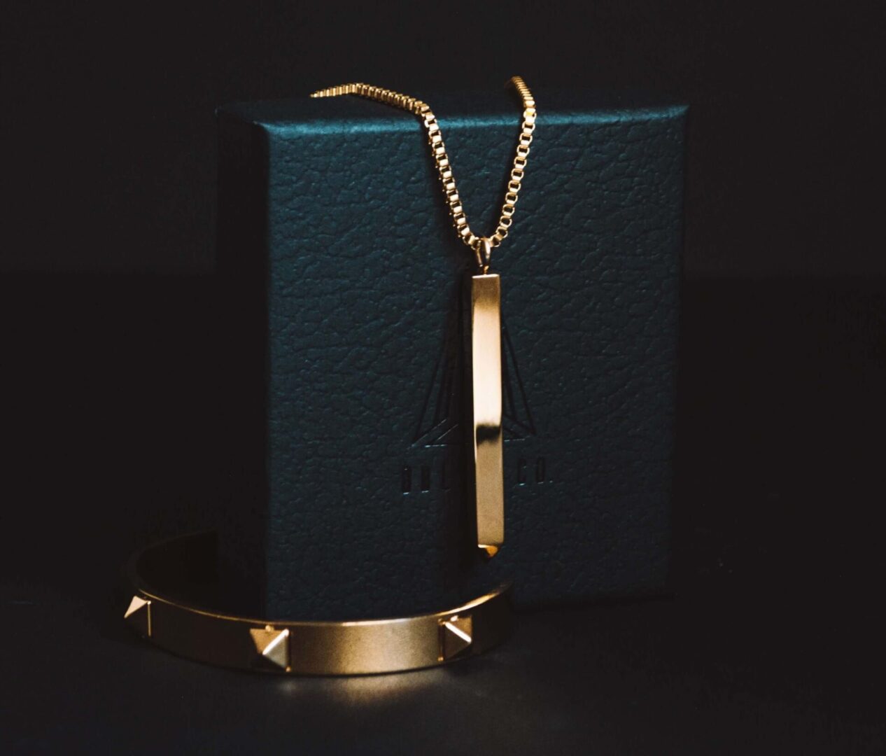A gold necklace and bracelet sitting on top of a box.