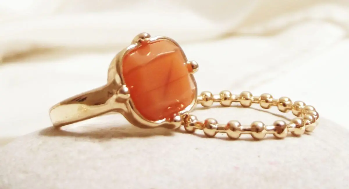 A close up of an orange stone on a chain