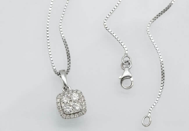 A diamond necklace with a chain attached to it.